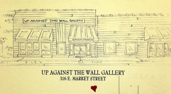 A pen sketch of the storefront on cream paper: the sign, the awnings marked Custom Framing, the windows and door, and beneath it the words Up Against the Wall Gallery, 316 E. Market Street